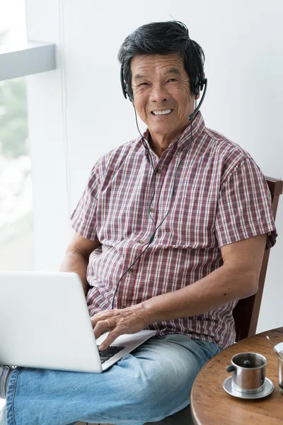 Homem sênior trabalhando no laptop — Fotografia de Stock