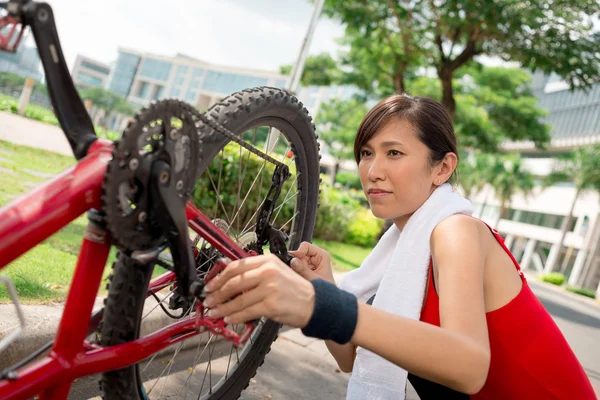 Mulher asiática reparando bicicleta — Fotografia de Stock