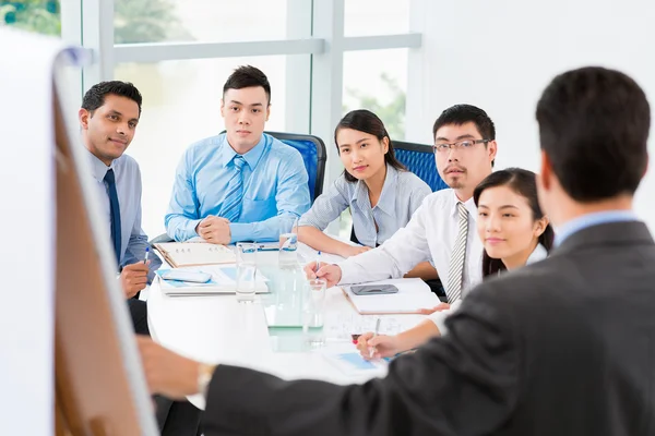 Employees listening to chief Stock Image