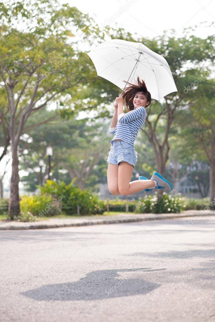 Pretty girl jumping with umbrella
