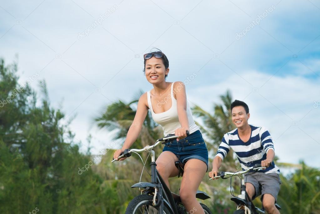 Happy couple riding on bicycles