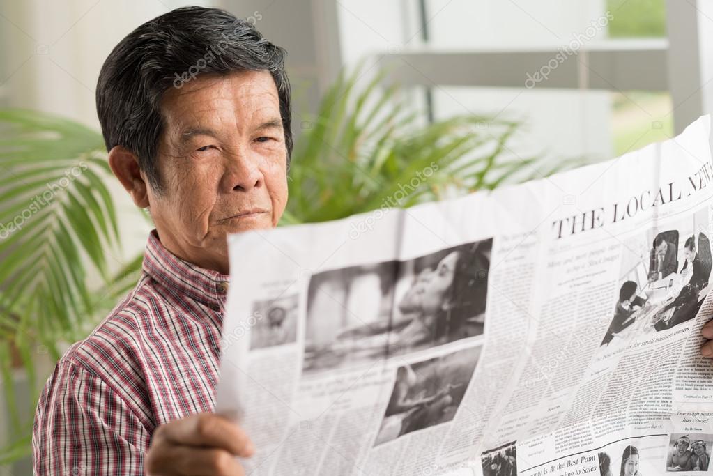 Vietnamese man reading newspaper