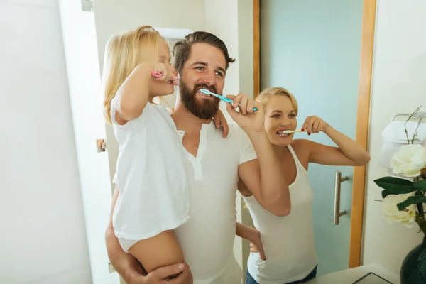 Pais e filha escovando os dentes — Fotografia de Stock