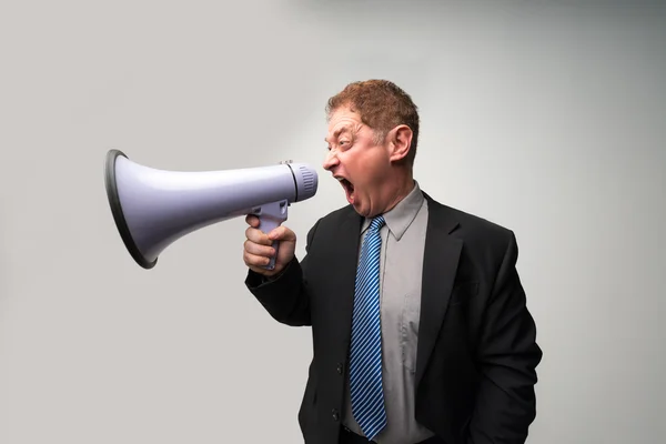 Homem de negócios zangado gritando em megafone — Fotografia de Stock