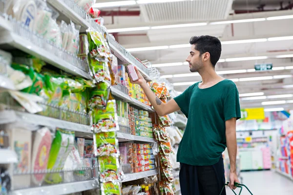 若い男がインスタント食品を買う — ストック写真