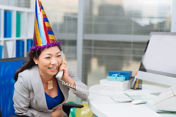 Businesswoman in party hat talking — Stock Photo, Image
