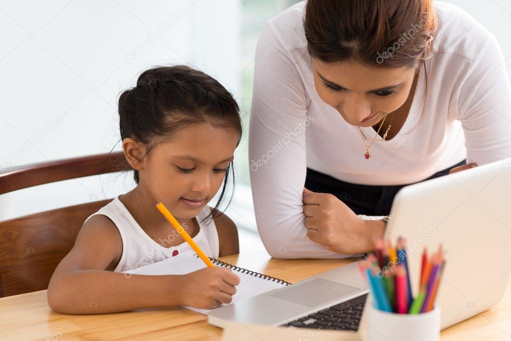 Woman helping girl with homework