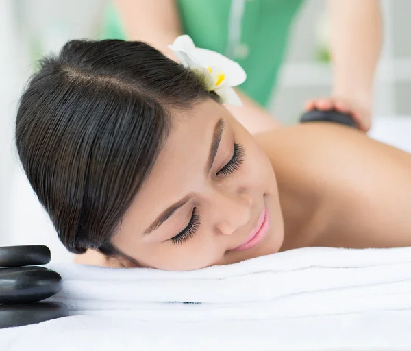 Vrouw genieten van stone-massage — Stockfoto