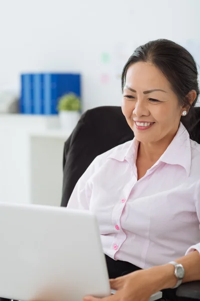 Mulher madura usando laptop — Fotografia de Stock