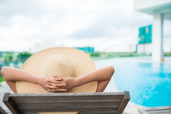 Femme se relaxant au bord de la piscine — Photo