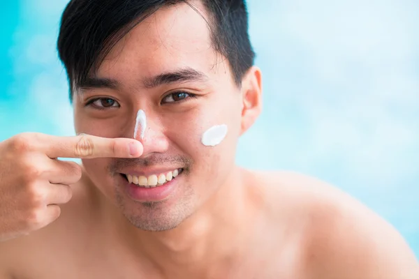 Man applying sunscreen on his face — Stock Photo, Image