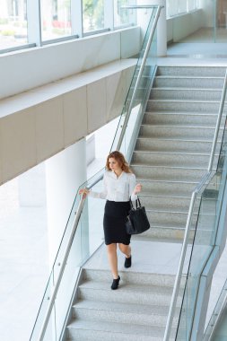 Alt katta ofis binası içinde yürüyüş iş kadını