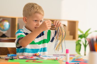 Renkli kağıt ile çalışan bir çocuk