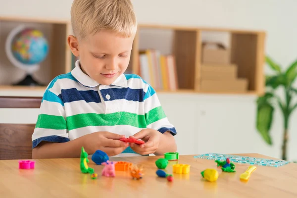 Ragazzo stampaggio da plastilina colorata — Foto Stock