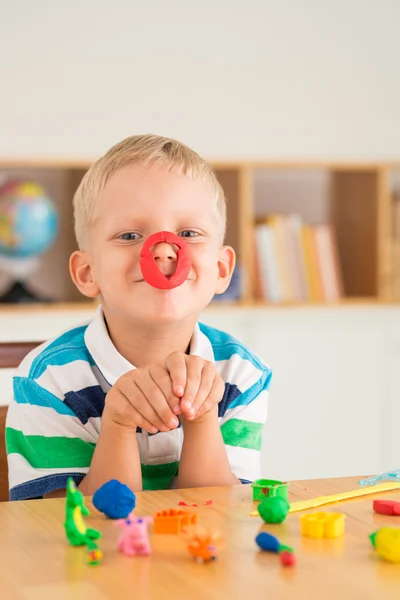 Niño posando con plastilina en la nariz — Foto de Stock
