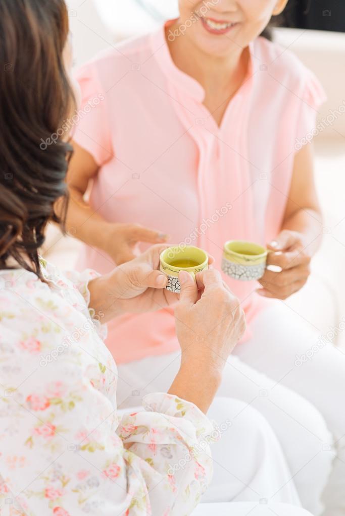 Friends at home talking and drinking tea