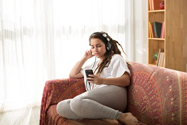 Девушка с дредами слушает музыку — стоковое фото