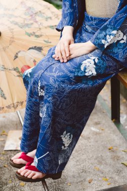 Kimono ve geta ayakkabı giyiyor