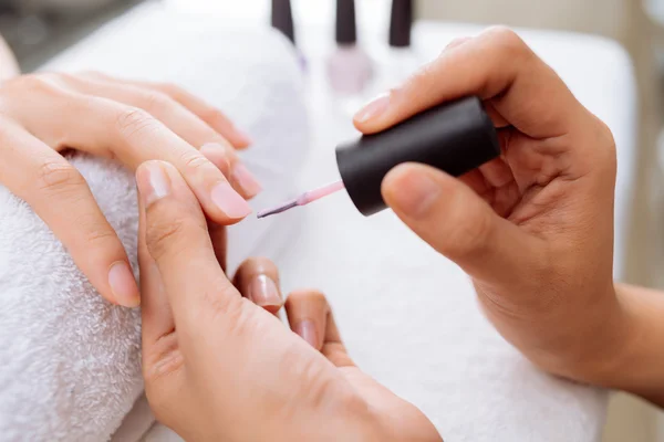 Mujer aplicando esmalte de uñas rosa —  Fotos de Stock