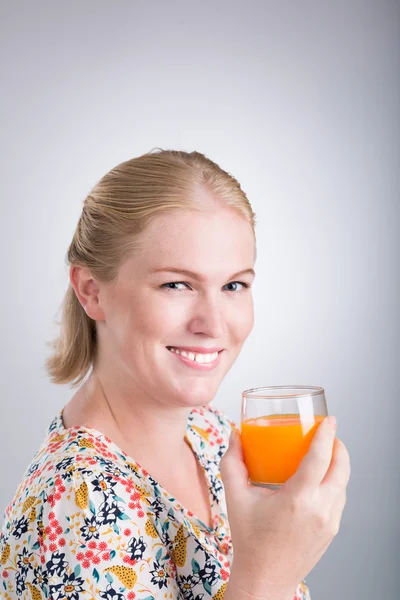 Kvinna med ett glas apelsinjuice — Stockfoto