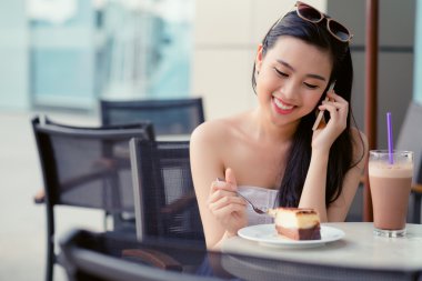 Kafede oturan ve telefonda konuşurken kız