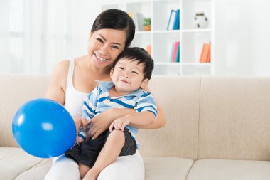 Anne ve oğlu kanepede oturan