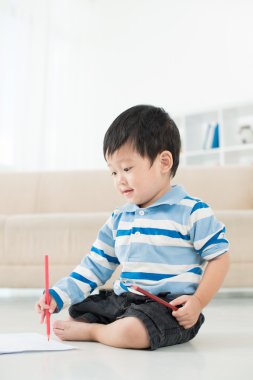 Katta oturan ve çizim çocuk