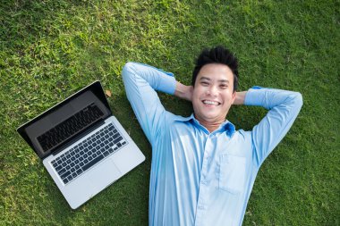 Adam ile laptop çimenlerin üzerinde rahatlatıcı