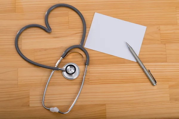 Stetoskop w kształcie serca, papier i długopis — Zdjęcie stockowe