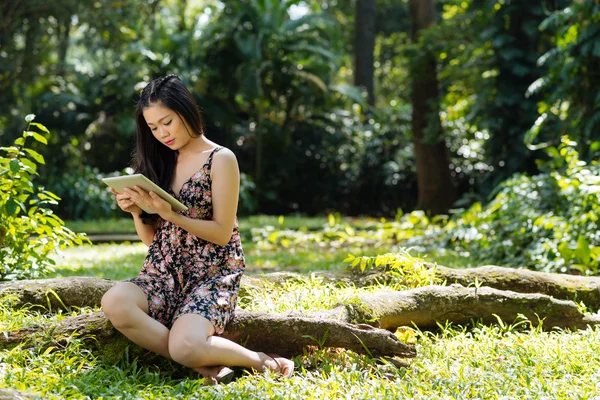Chica con tableta digital en el bosque — Foto de Stock