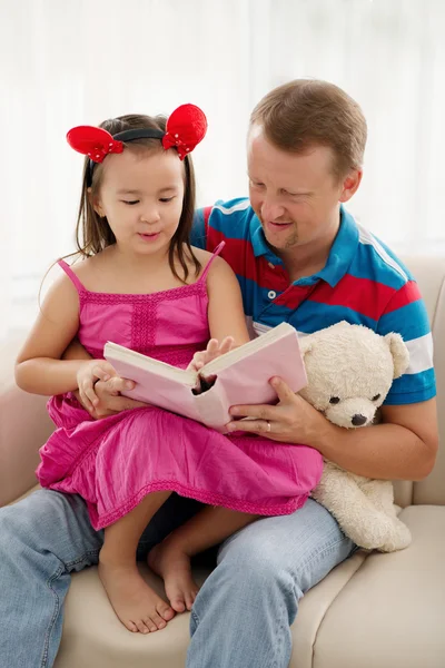 Far och dotter läser en bok tillsammans — Stockfoto