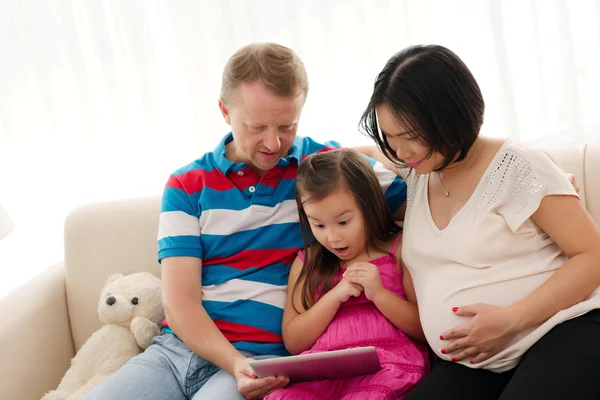 Flickan tittar på digital tablet med föräldrar — Stockfoto