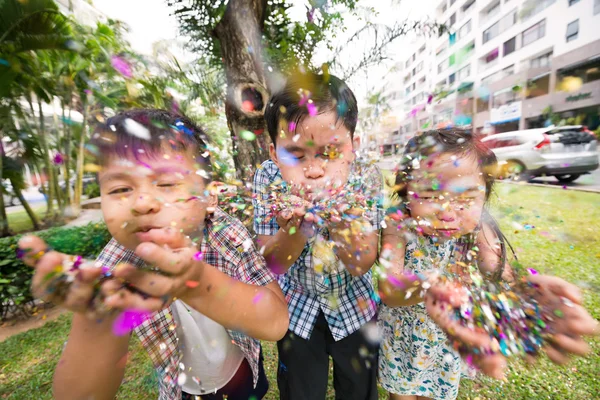 Children blowing confetti — Stock Photo, Image