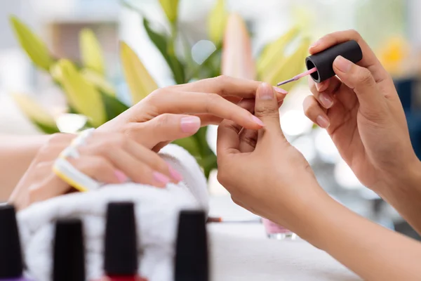 Esteticista cubriendo los clavos del cliente —  Fotos de Stock