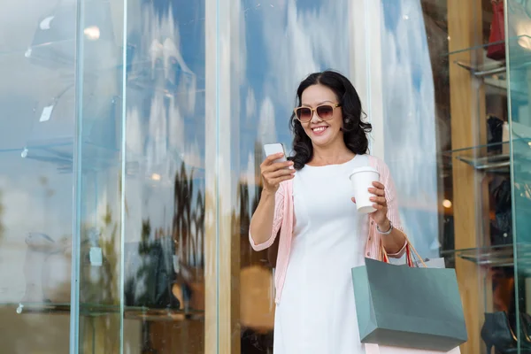 Vrouw met koffie en shopping tassen — Stockfoto