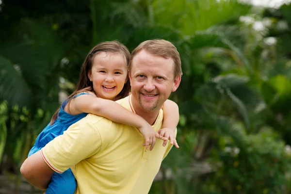 Pai dando passeio de piggyback para filha — Fotografia de Stock