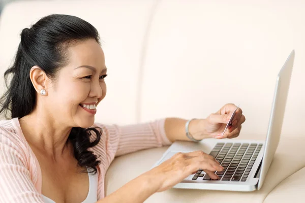 Mature woman inputting card information — Stock Photo, Image