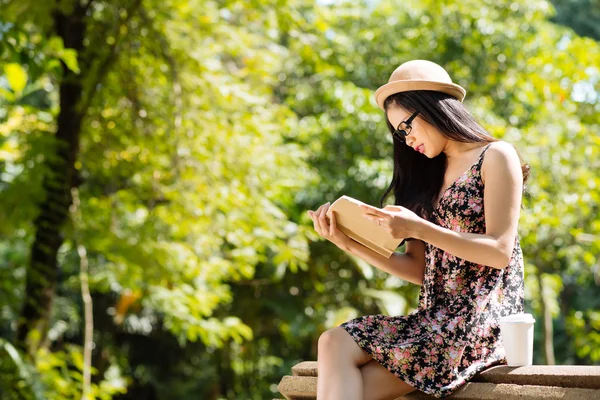 Fille lisant un livre dans le parc — Photo