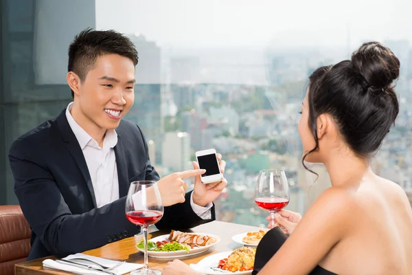 Man showing his girlfriend a smartphone — Stock Photo, Image