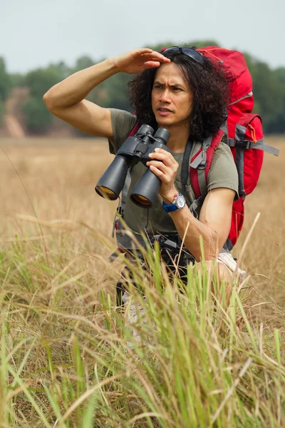 Serious traveler with binoculars — Stock Photo, Image