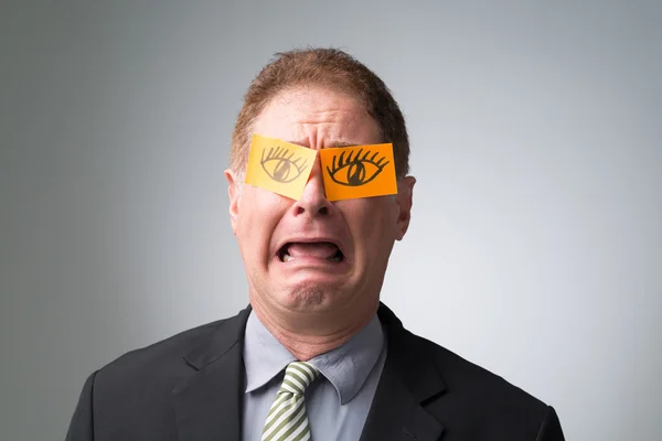 Businessman with eyes drawn on sticky notes — Stock Photo, Image