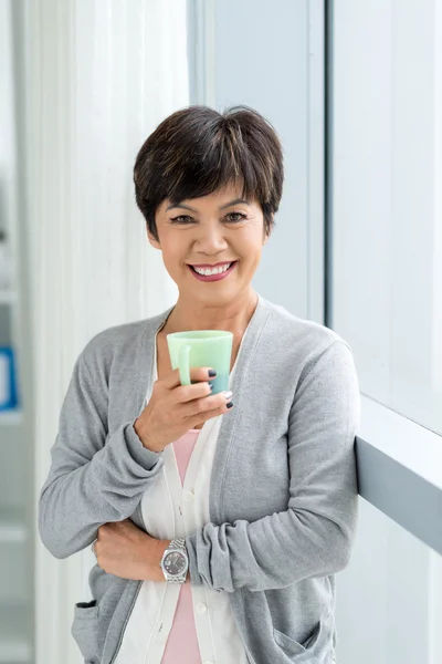 Rijpe Brunette met een kopje koffie — Stockfoto