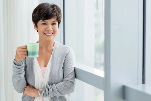 Femme âgée souriante avec une tasse de thé — Photo