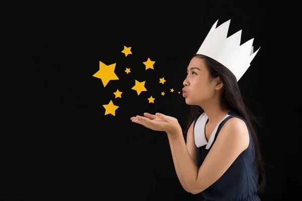 Girl in paper crown blowing stardust — Stock Photo, Image