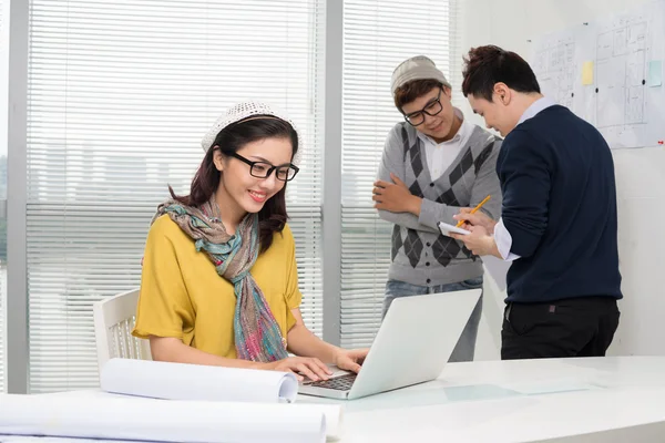 Informatica femminile mentre i colleghi discutono — Foto Stock