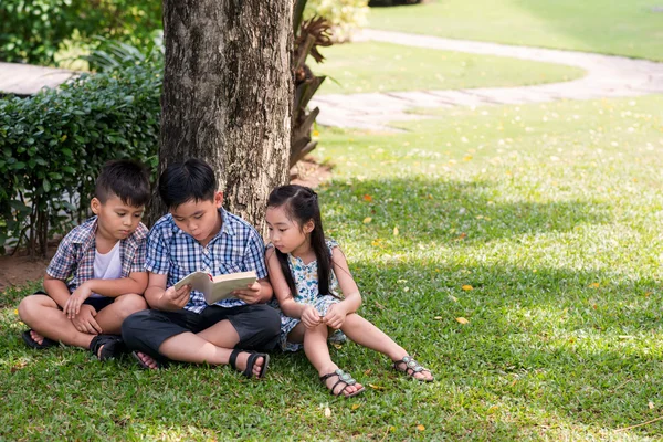 Ağacın altında oturan çocuk