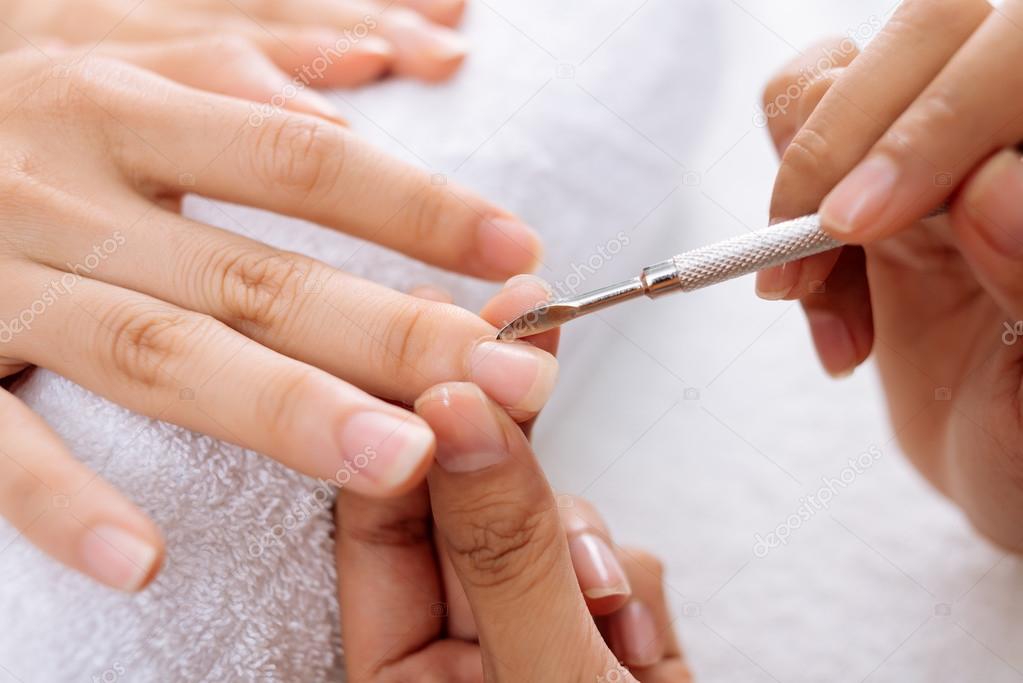 Manicurist removing cuticle