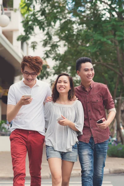 Glada vänner med smartphones — Stockfoto
