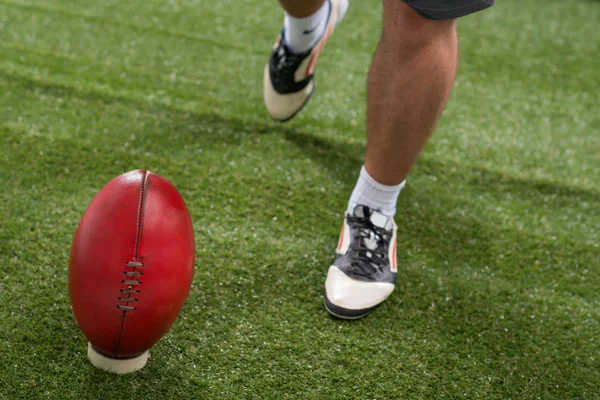 Joueur de football donnant un coup de pied au ballon — Photo