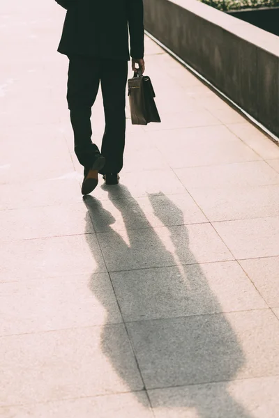 Affärsman promenader med en portfölj — Stockfoto